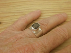 Thorite (Uranium Thorium Silicate) crystal in silver ring for accupuncture stimulation.